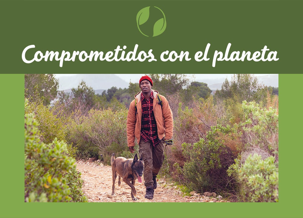 Hombre caminando con su perro, con aviso Comprometidos con el planeta